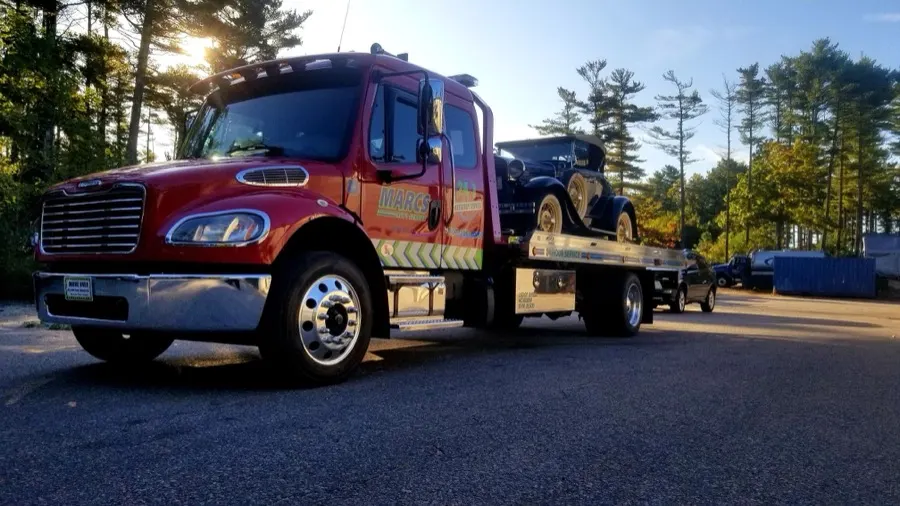 Red flatbed carrying a vehicle