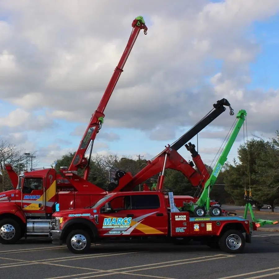 Two wreckers with booms raised